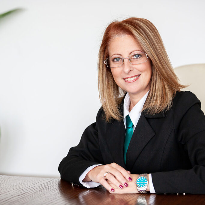 Adult businesswoman in her 40 s smiling at the camera in her office